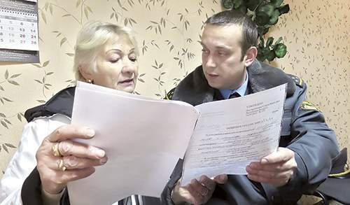 Сергей Михеев вручает защитное предписание Валентине Красновой: ее сыну на время запрещено приходить к матери, звонить и даже писать SMS.