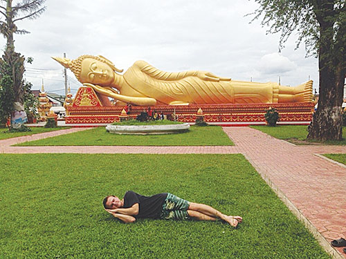 Андрей рядом со статуей Будды во Вьентьяне